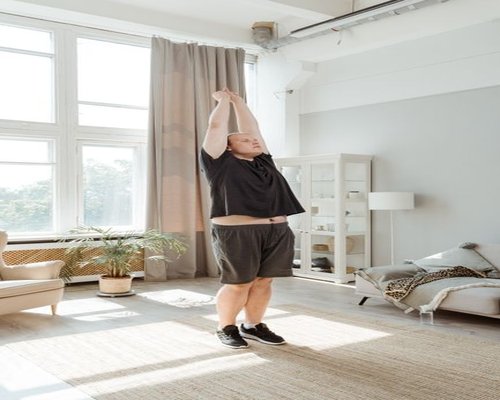 Person doing morning stretching exercises near a bright window